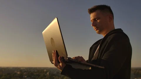 Programmer a hacker is on the roof with a laptop at sunset says error code on Stock Footage 116880252