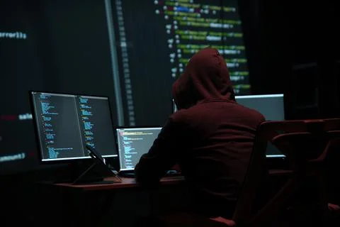 Programmer Hacker Working at Multiple Computer Monitors Stock-Fotos