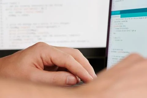 Programmer hands on blurred code Stock Photos