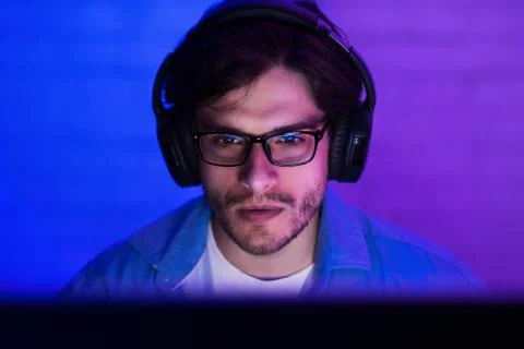 Programmer in headphones coding, working on computer Foto stock