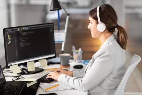 Programmer in headphones with computer at office Foto stock