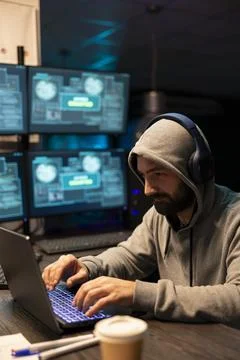 Programmer in headphones concentrates on writing software code Stock-Fotos