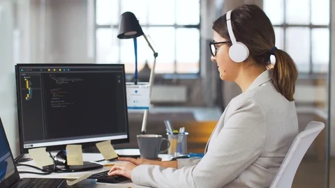 Programmer in headphones working on computer Stock Footage 105031602