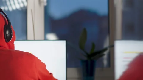 Programmer in headphones working on a computer at home, camera movement Stock Footage 150219178