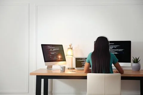 Programmer with headphones working at desk in office Foto stock