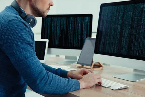 Programmer with headphones working at desk in office, closeup 写真素材