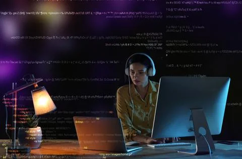 Programmer with headphones working in office at night Foto stock