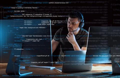 Programmer with headphones working in office at night Foto stock