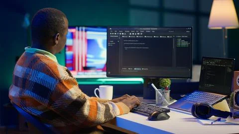 Programmer in home office concentrating on finding bugs while he codes 스톡 사진