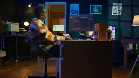 Programmer in home office concentrating on finding bugs while he codes 스톡 사진