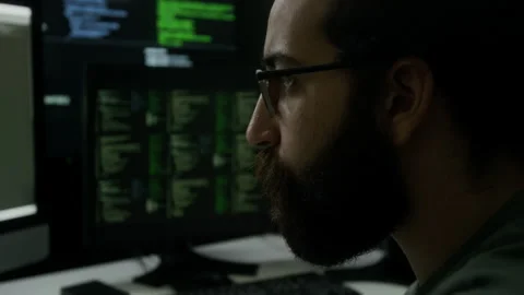 Programmer Intensely Watching Running Lines of Code on Multiple Monitors Stock Footage 302195574