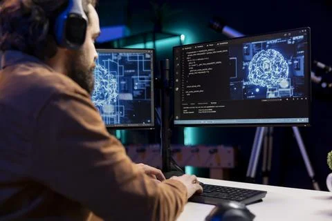 Programmer listening music while doing maintenance on artificial intelligence Stock Photos
