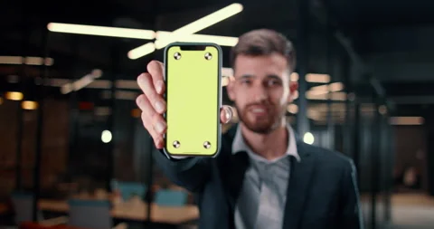 Programmer looking at his creation and showing screen of smartphone on chroma Stock-Footage 224305348