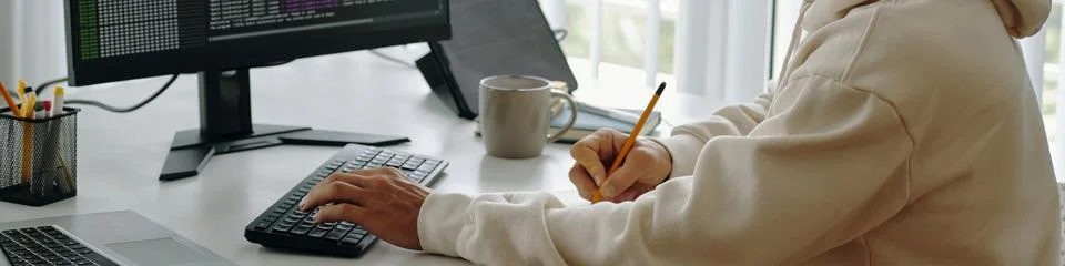 Programmer Making Notes At Workplace 库存照片