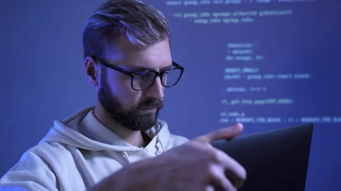 Programmer man with beard and glasses opens laptop to work from home, code anima Stock Footage 128536398