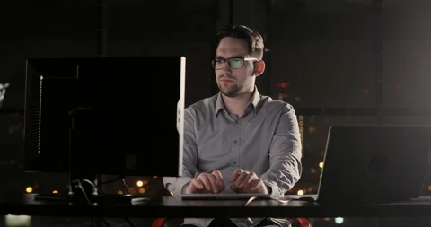 Programmer man is working in the office overtime typing on keyboard late at Stock Footage 105301792