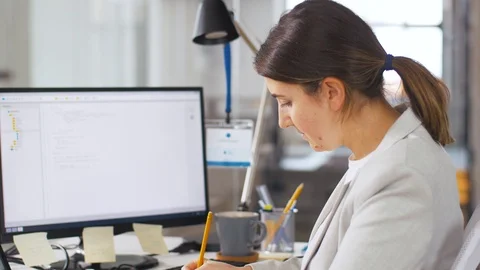 Programmer with notes and computer works at office Stock Footage 105030000