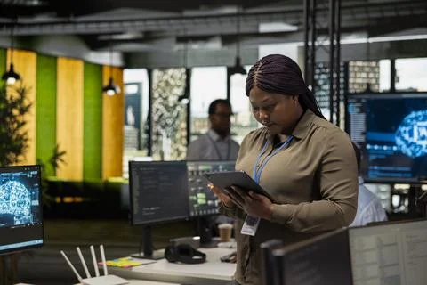 Programmer in office automating repetitive tasks using AI scripts on tablet Stock Photos