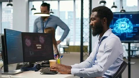 Programmer in office requesting help from coworkers to fix critical error Foto stock