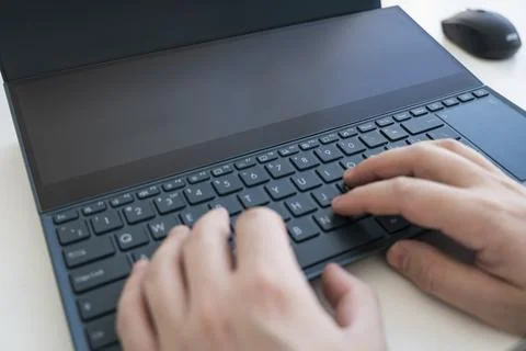 Programmer or computer hacker typing code on laptop keyboard. The keypad is l 库存照片