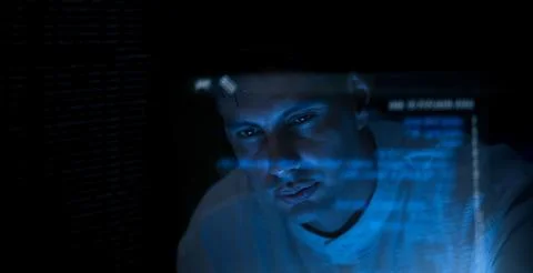 Programmer or Developer working in dark room with computer code reflected o.. Stock Photos