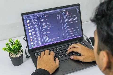 A programmer or web developer is sitting at a desk. Stock Photos
