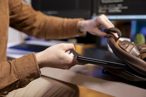Programmer packing laptop in backpack, leaving office Photos