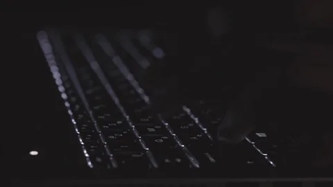 The programmer prints the code on the laptop's luminous keyboard Stock Footage 73455515