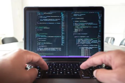 Programmer profession - man writing programming code on laptop computer. Stock Photos