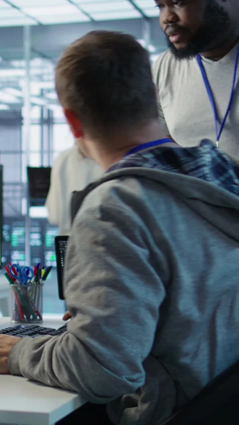 Programmer requesting help from manager while working on computer in data center Stock Footage 319550610