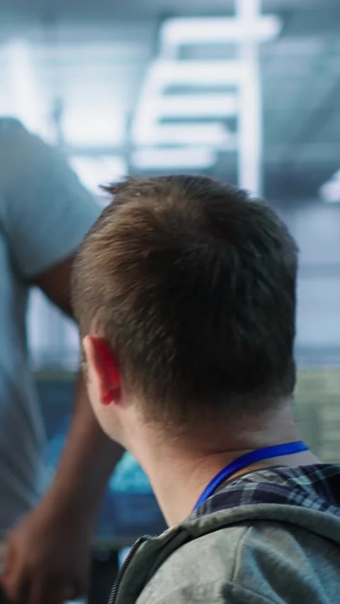 Programmer requesting help from manager while working on computer in data center Stock Footage 319556104