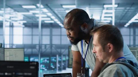 Programmer requesting help from manager while working on computer in data center 스톡 사진