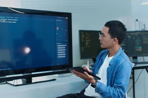 Programmer Reviewing Digital Code on a Tablet Stock Photos