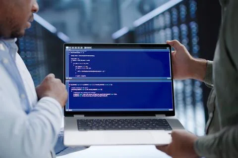 Programmer Reviews Code Security Details While Working In Busy Server Room. Stockfoto's