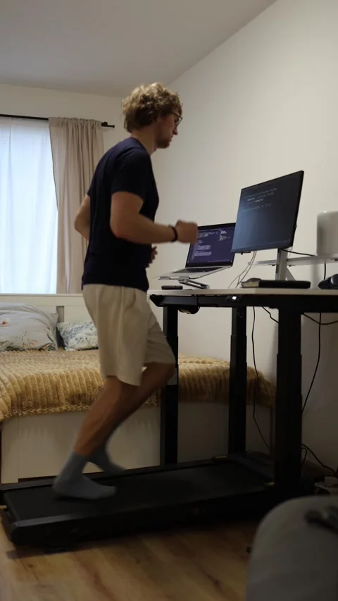 Programmer runs on treadmill while studying IT and analyzing code Stock Footage 346881430