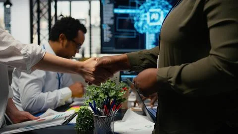 Programmer shaking hand with businessmen in tech agency boardroom Foto stock