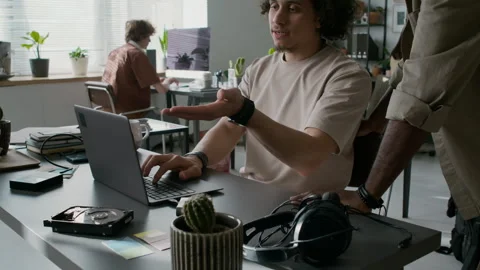 Programmer Showing New Software to Coworker, Both Looking at Laptop Screen Stock Footage 299328417