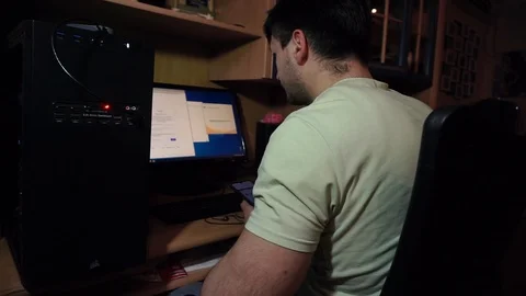 Programmer from smartphone rewrites password, code, on computer, on the keyboard Stock Footage 121478068