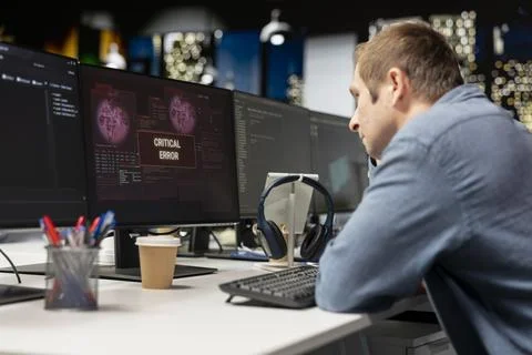 Programmer in startup office struggling to fix application errors while coding Stock Photos
