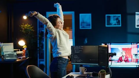 Programmer stretches body limbs after securing company servers from virus Stock Photos