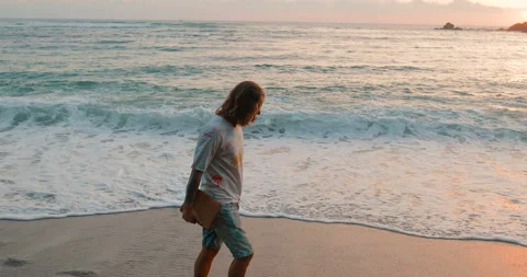 A programmer with a tablet in hand is walking along the beach Stock Footage 105734388