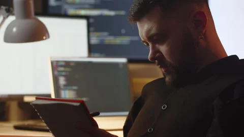Programmer taking notes in the office. Selective focus of bearded man writing Stock Footage 237327863