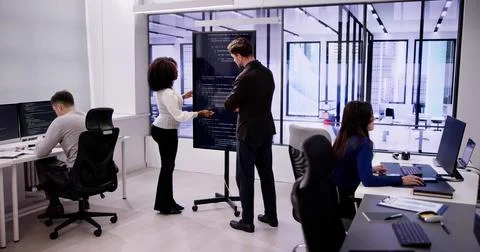 Programmer Team Meeting With TV Screen In Office Stock Photos