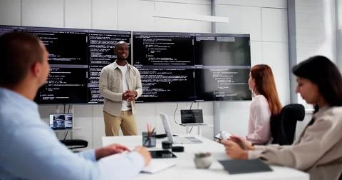 Programmer Team Meeting With TV Screen In Office. Diverse Developers Stock Photos