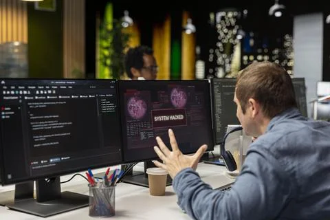 Programmer in tech company office trying to fix hacking attempt on network Stock-Fotos