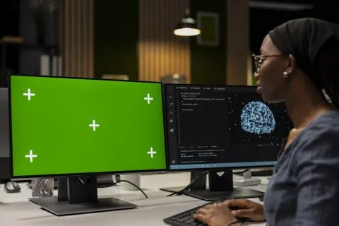Programmer in tech startup office developing apps using AI on green screen PC 写真素材