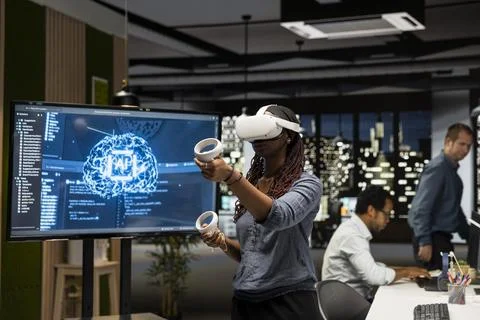 Programmer in tech startup office using VR headset and AI to automate tasks 库存照片