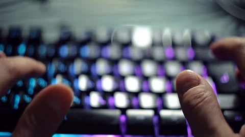 Programmer typing code on a backlit keyboard in a dark room, passionate work at Stock Footage 118574828