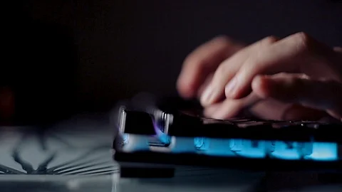 Programmer typing code on a backlit keyboard in a dark room, passionate work at Stock-Footage 118696389