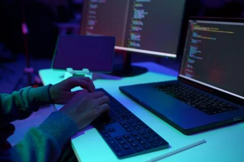Programmer Typing Code on Laptop in Neon Lit Workspace Stock Photos